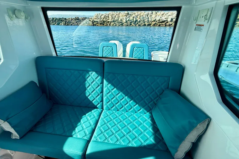Slide: The Image of Interior of 2021 Axopar Brabus 28 Cabin with turquoise seating and ocean view. - 53