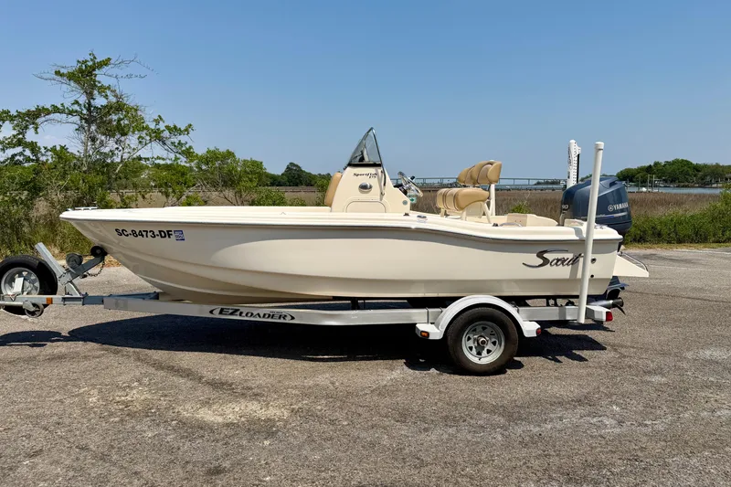 The Image of 2017 Scout 175 Sportfish boat on trailer, parked outdoors with scenic background. - 0