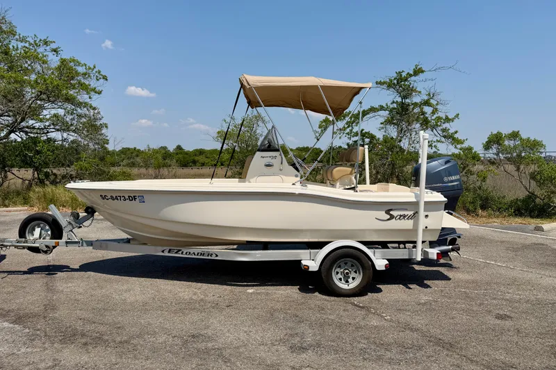 Slide: The Image of 2017 Scout 175 Sportfish boat on trailer with canopy, parked outdoors. - 3