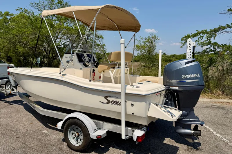 Slide: The Image of 2017 Scout 175 Sportfish boat with Yamaha engine on trailer, parked outdoors. - 5