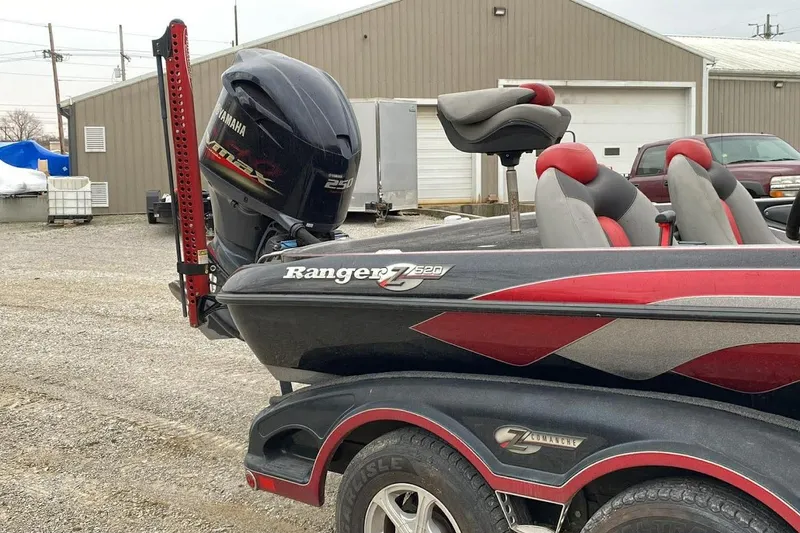 Slide: The Image of 2011 Ranger Z520 boat with Yamaha engine, parked outdoors near industrial buildings. - 13