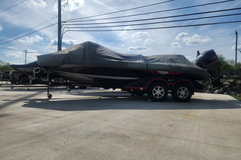 Slide: The Image of 2011 Ranger Z520 boat covered on trailer, parked outdoors under a clear sky. - 2