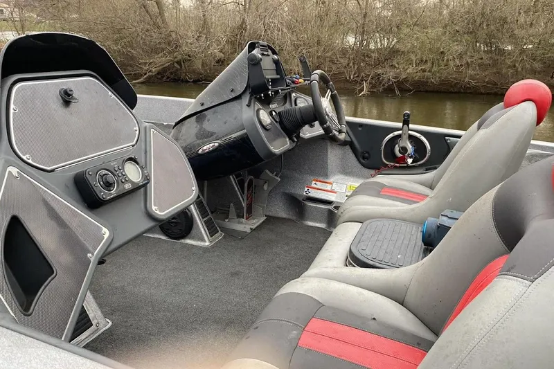 Slide: The Image of 2011 Ranger Z520 boat interior with steering wheel, seats, and control panel by a river. - 8