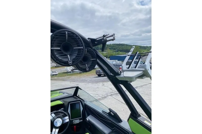 Slide: The Image of 2022 Tigé Z3 boat with speakers and wakeboard rack, parked outdoors. - 11