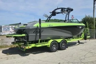Slide: The Image of 2022 Tigé Z3 boat on trailer, lime green and gray design, parked outdoors. - 4
