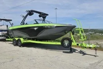 Slide: The Image of 2022 Tigé Z3 boat on trailer, vibrant green and black design, parked outdoors. - 5