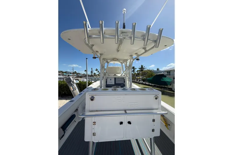 Slide: The Image of 2006 SeaVee 290B boat with fishing rod holders and console, docked under clear skies. - 10