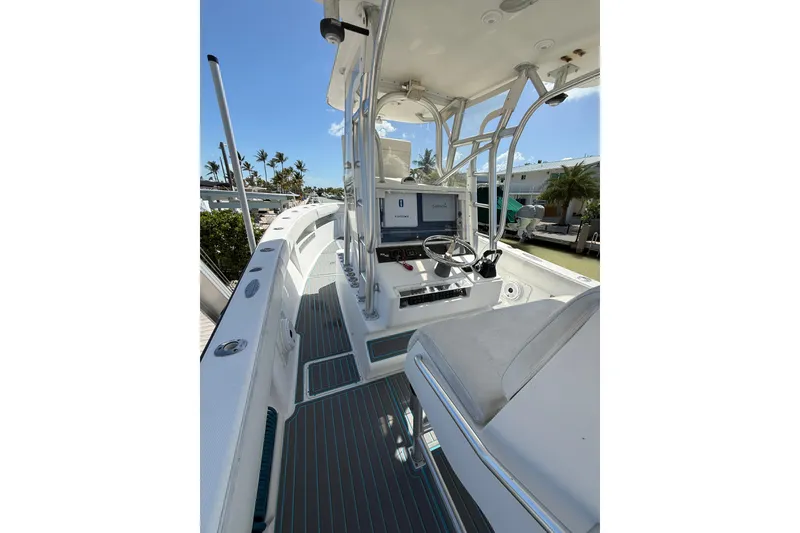 Slide: The Image of 2006 SeaVee 290B boat interior with helm, seating, and navigation equipment under clear sky. - 12