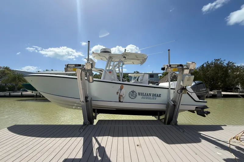 Slide: The Image of 2006 SeaVee 290B boat on lift, clear sky, dockside view. - 2