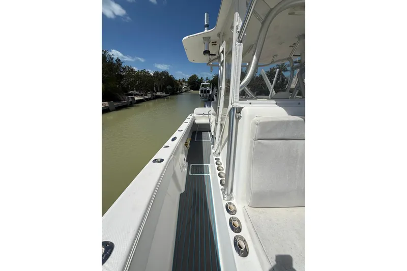 Slide: The Image of 2006 SeaVee 290B boat docked on a calm waterway under a clear blue sky. - 28