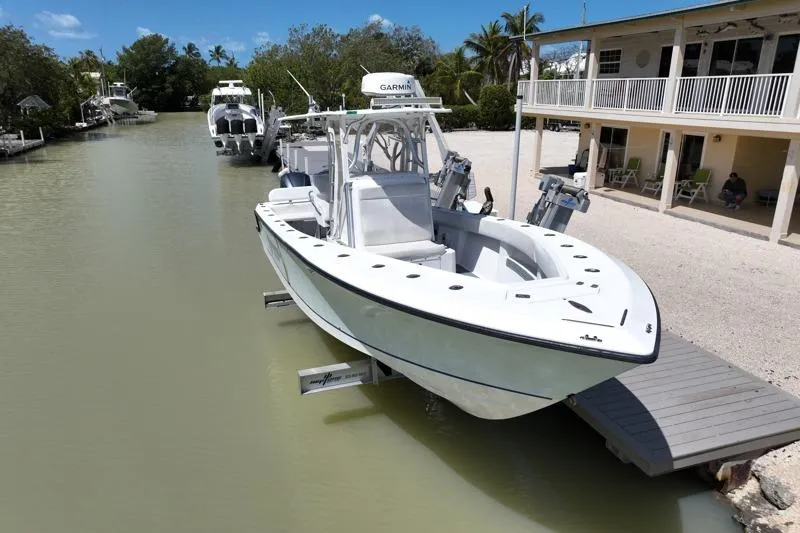 Slide: The Image of 2006 SeaVee 290B boat docked by a waterfront house, surrounded by lush greenery. - 29