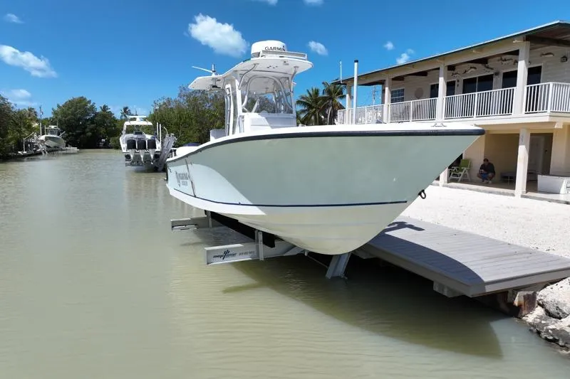Slide: The Image of 2006 SeaVee 290B boat docked by waterfront house under clear blue sky. - 31