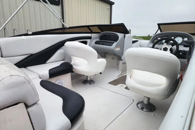 Slide: The Image of Interior of a 2006 Reinell 220 LSE boat with white seating and dashboard. - 2