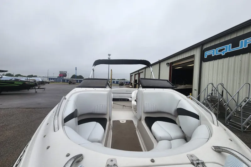 Slide: The Image of 2006 Reinell 220 LSE boat with white interior, parked outside a warehouse. - 4