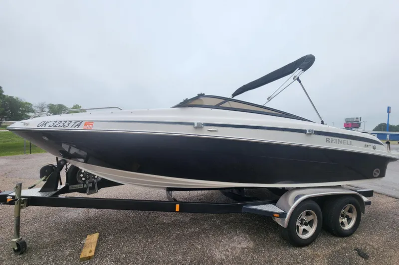 Slide: The Image of 2006 Reinell 220 LSE boat on trailer with canopy, parked outdoors. - 5