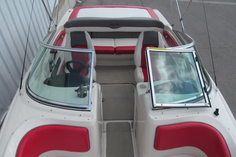 Slide: The Image of 2006 Sea Ray 205 Sport boat interior with red and white seating, open windshield. - 11