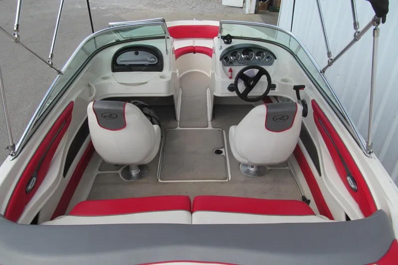 Slide: The Image of 2006 Sea Ray 205 Sport boat interior with red and white seating, steering wheel, and dashboard. - 5