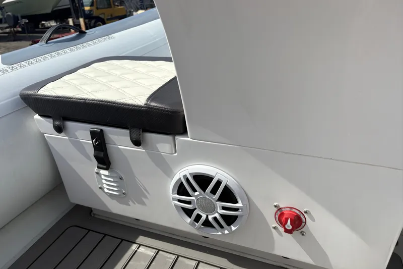 Slide: The Image of 2024 Highfield Sport 360 boat interior with cushioned seat, speaker, and control knob. - 16