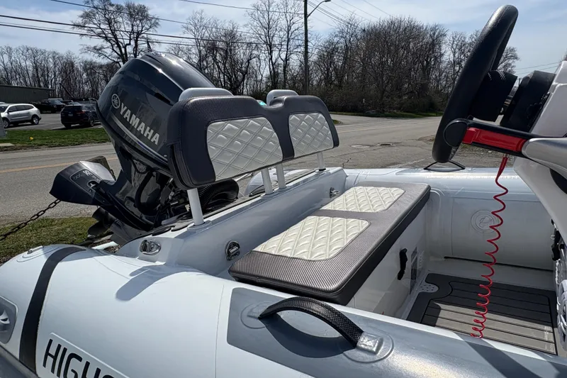 Slide: The Image of 2024 Highfield Sport 360 boat interior with Yamaha engine, featuring quilted seating and steering console. - 2