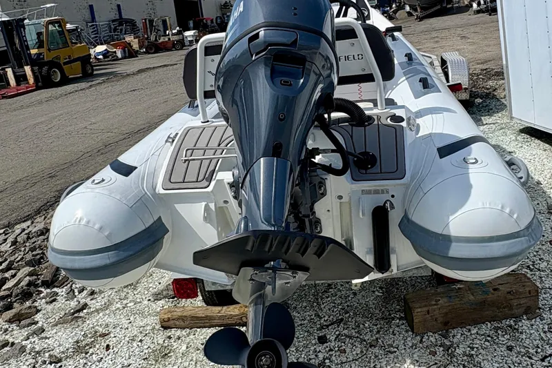 Slide: The Image of 2024 Highfield Sport 360 boat with Yamaha outboard motor, parked on gravel. - 3