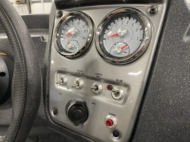 Slide: The Image of Dashboard of 2026 Tracker Pro Guide V-16 SC with switches and gauges. - 27