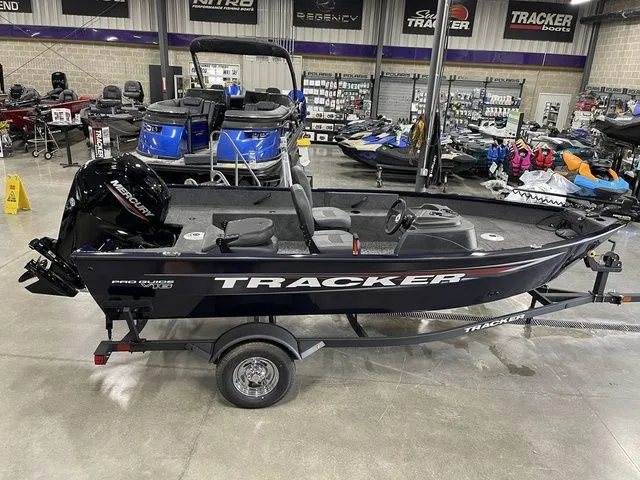 Slide: The Image of 2026 Tracker Pro Guide V-16 SC boat in showroom. - 3