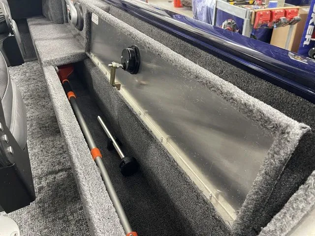 Slide: The Image of Interior of 2026 Tracker Pro Guide V-16 SC with storage and tools. - 33