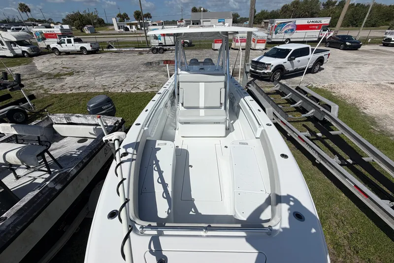 Slide: The Image of 2023 Contender 28 Tournament boat on trailer, parked outdoors with vehicles nearby. - 2