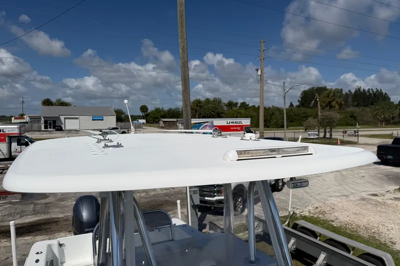 Slide: The Image of 2023 Contender 28 Tournament boat with T-top, parked outdoors under a clear blue sky. - 21