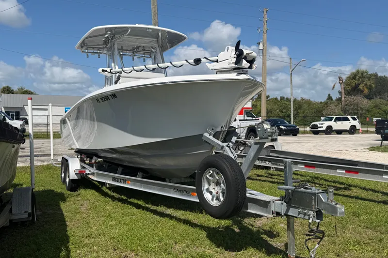 Slide: The Image of 2023 Contender 28 Tournament boat on trailer, parked outdoors under blue sky. - 25