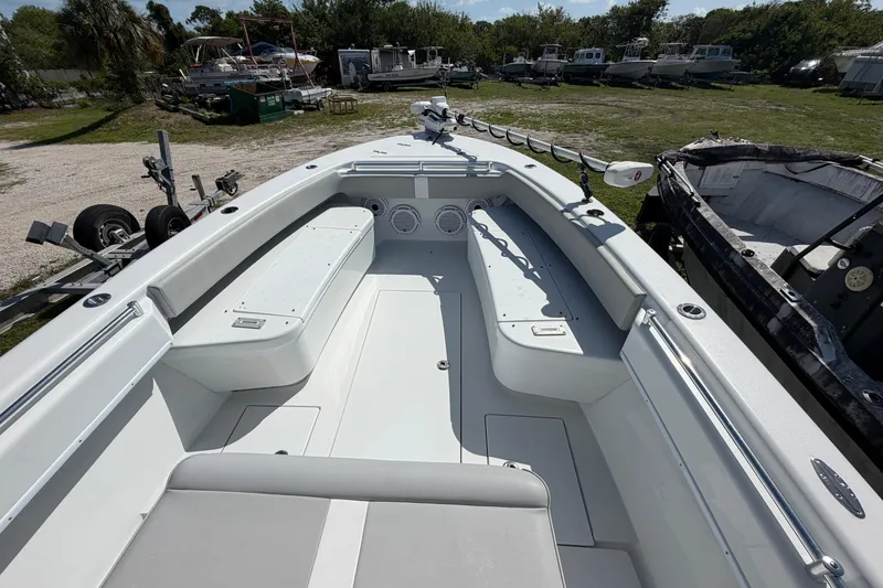 Slide: The Image of 2023 Contender 28 Tournament boat interior with seating and storage, parked outdoors. - 27