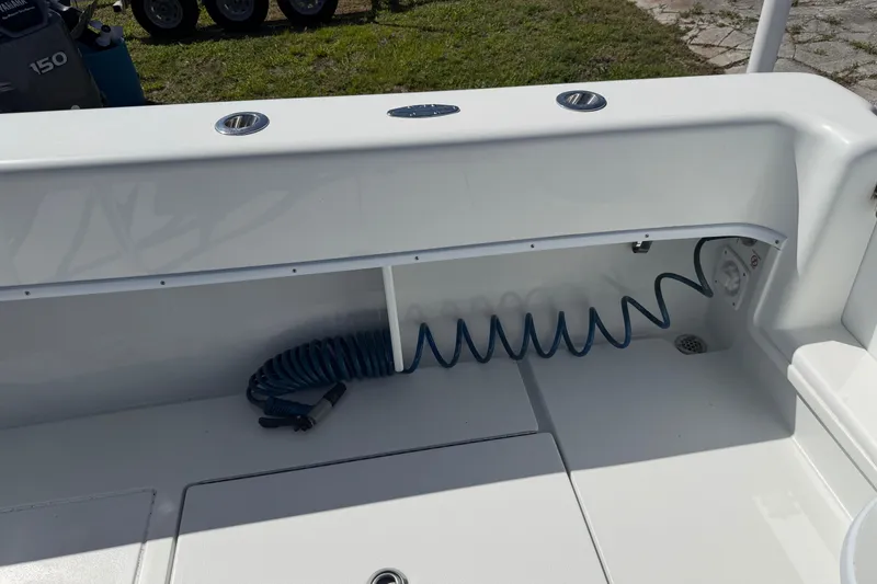 Slide: The Image of 2023 Contender 28 Tournament boat deck with coiled hose and storage compartment. - 39