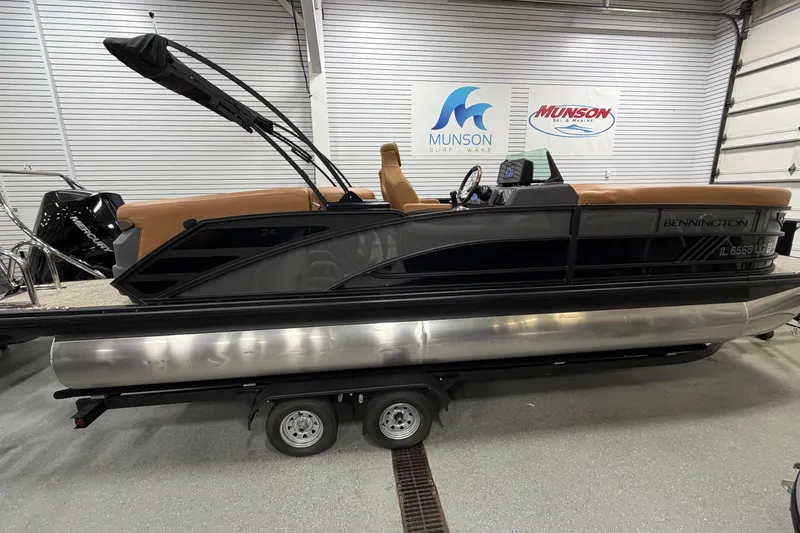 The Image of 2025 Bennington M Quad Bench 24 MFB pontoon boat on trailer in showroom. - 0
