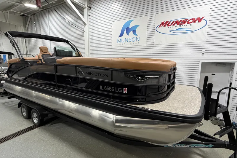 Slide: The Image of 2025 Bennington M Quad Bench 24 MFB pontoon boat in showroom on trailer. - 2