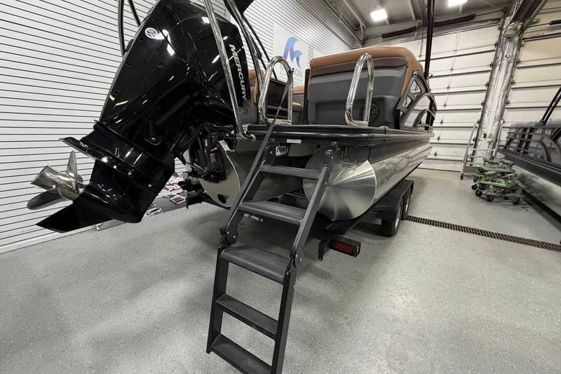 Slide: The Image of 2025 Bennington M Quad Bench 24 MFB pontoon boat with Mercury engine in showroom. - 5