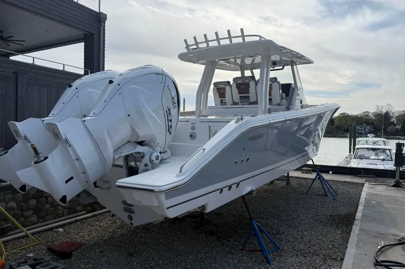 The Image of 2026 Pursuit S 358 Sport boat with dual engines on display at a marina. - 0
