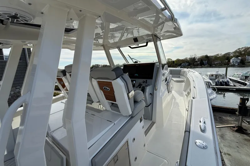 Slide: The Image of 2026 Pursuit S 358 Sport boat interior with helm and seating, docked by the water. - 12