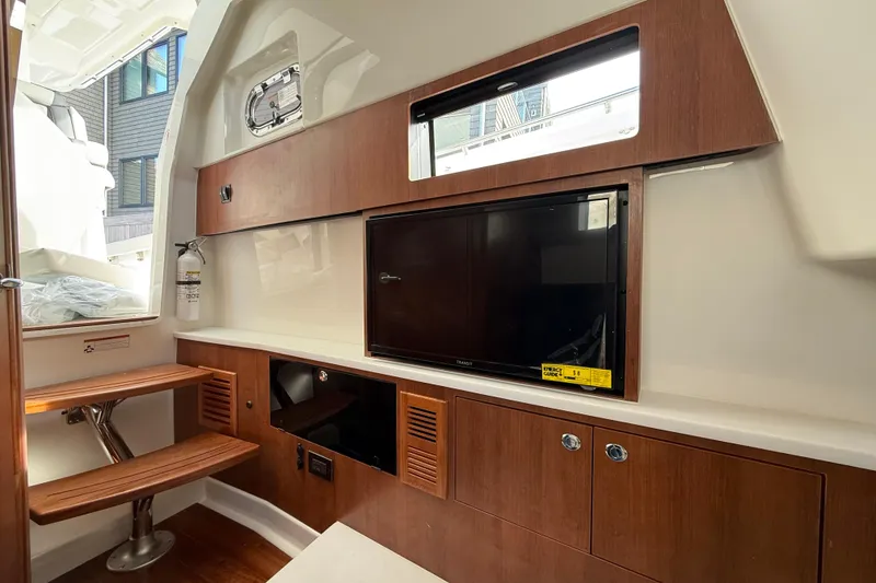 Slide: The Image of Interior of 2026 Pursuit S 358 Sport boat with wooden cabinetry and TV. - 14