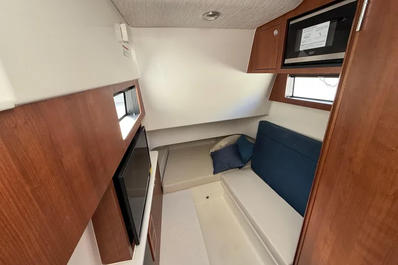 Slide: The Image of 2026 Pursuit S 358 Sport cabin interior with seating, TV, and microwave. - 15