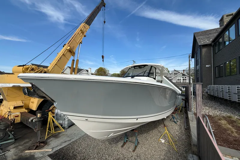 Slide: The Image of 2026 Pursuit S 358 Sport boat on stands, with crane in background. - 2