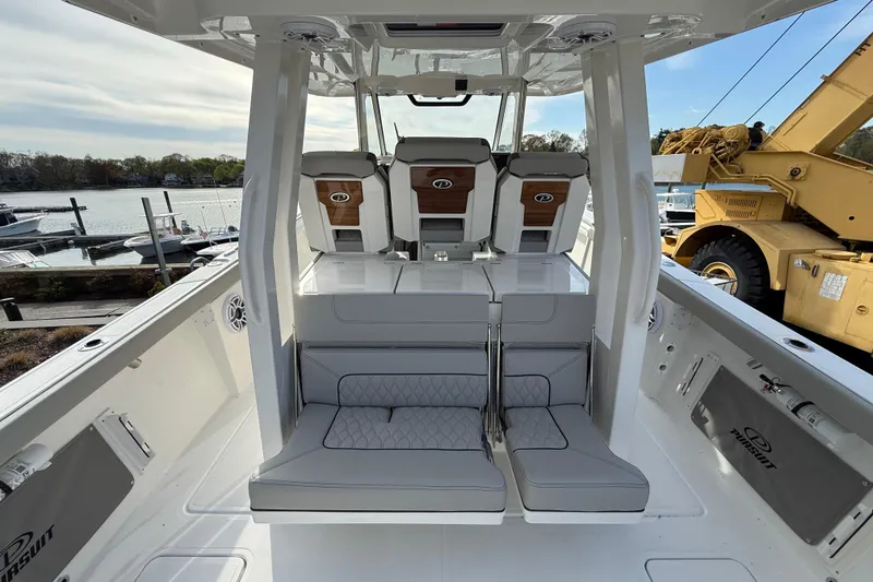 Slide: The Image of 2026 Pursuit S 358 Sport boat interior with seating and helm, dockside view. - 5