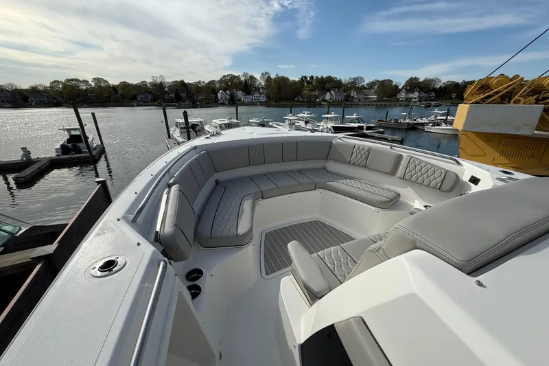 Slide: The Image of 2026 Pursuit S 358 Sport boat with spacious seating, docked in a scenic marina. - 9