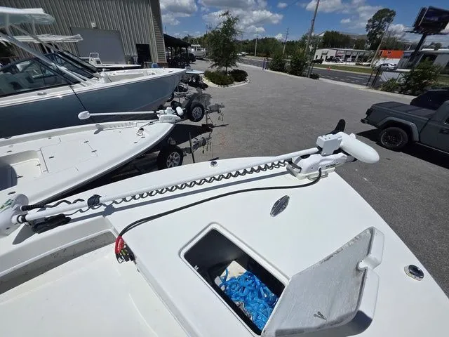 Slide: The Image of 2023 C-Hawk 25 Center Console with trolling motor on parking lot. - 25