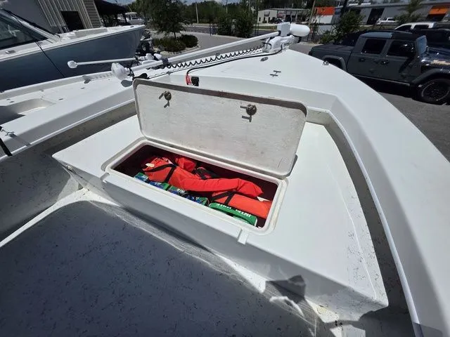 Slide: The Image of 2023 C-Hawk 25 Center Console with open storage compartment and life jackets. - 27