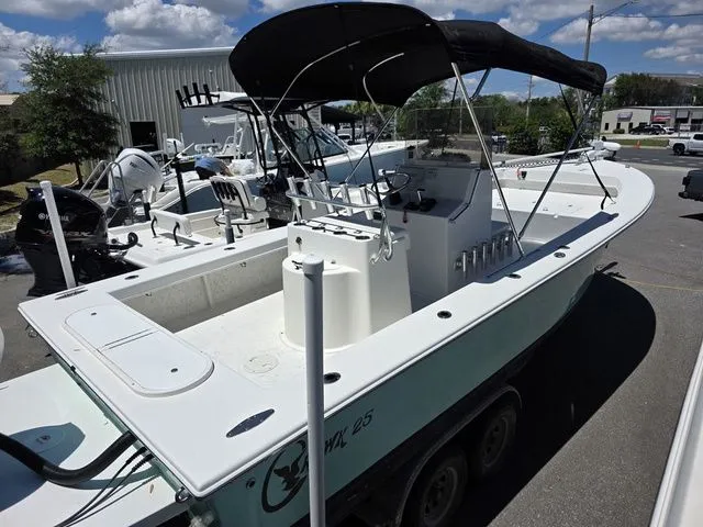 Slide: The Image of 2023 C-Hawk 25 Center Console boat with black canopy outdoors. - 3