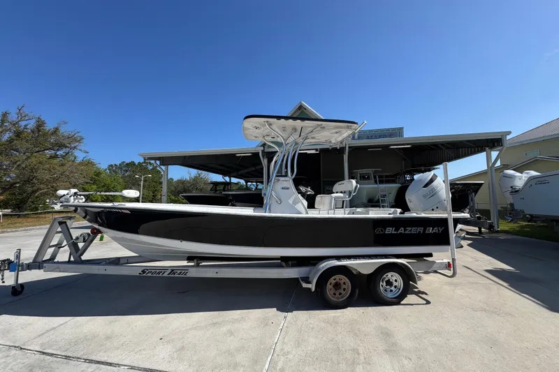 The Image of 2021 Blazer Bay 2400 boat on trailer under clear blue sky. - 1