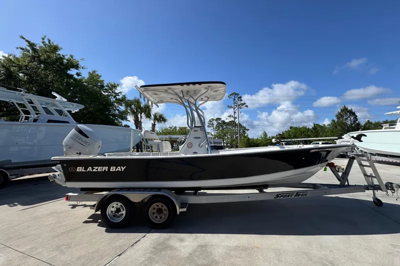Slide: The Image of 2021 Blazer Bay 2400 boat on trailer under clear blue sky. - 10