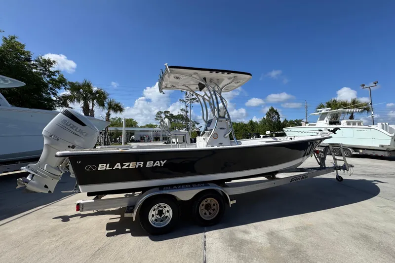 Slide: The Image of 2021 Blazer Bay 2400 boat on trailer, sunny day, palm trees in background. - 11