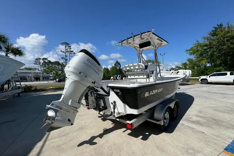 Slide: The Image of 2021 Blazer Bay 2400 boat with Suzuki outboard motor on trailer, parked outdoors. - 13