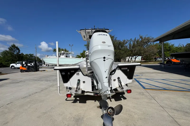 Slide: The Image of 2021 Blazer Bay 2400 boat with powerful outboard motor in a sunny marina. - 15